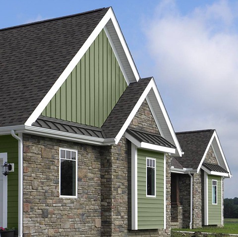 A House Featuring Green Siding Complemented by Elegant Stone Trim, Showcasing a Harmonious Blend of Colors and Textures.